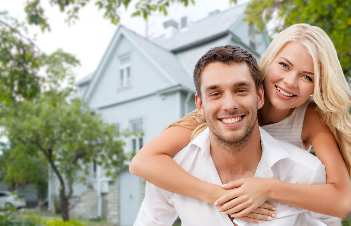 Young couple in front of their new house